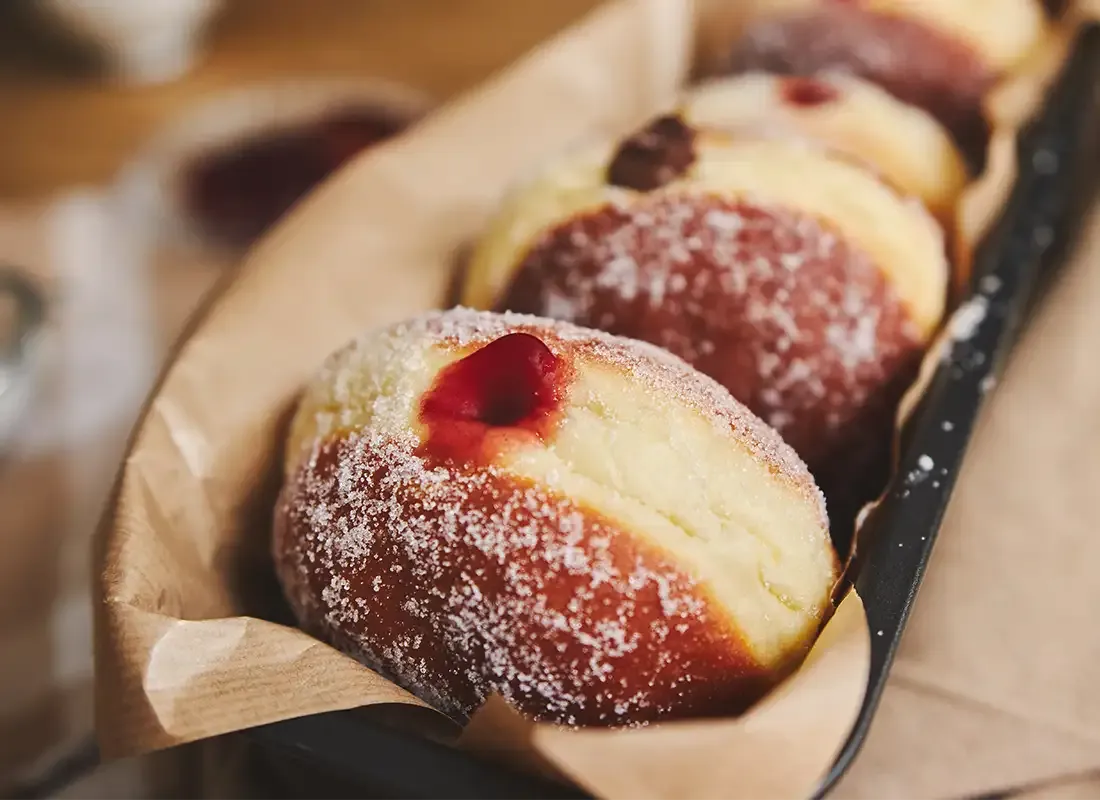 Hausgemachter Kreppel mit sichtbarer Konfitürenfüllung und Zuckerkruste