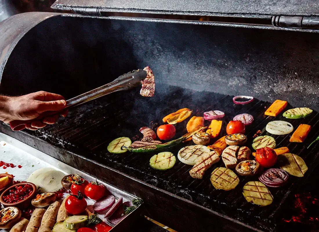 Buntes Gemüse und pflanzliche Würstchen auf einem Grill