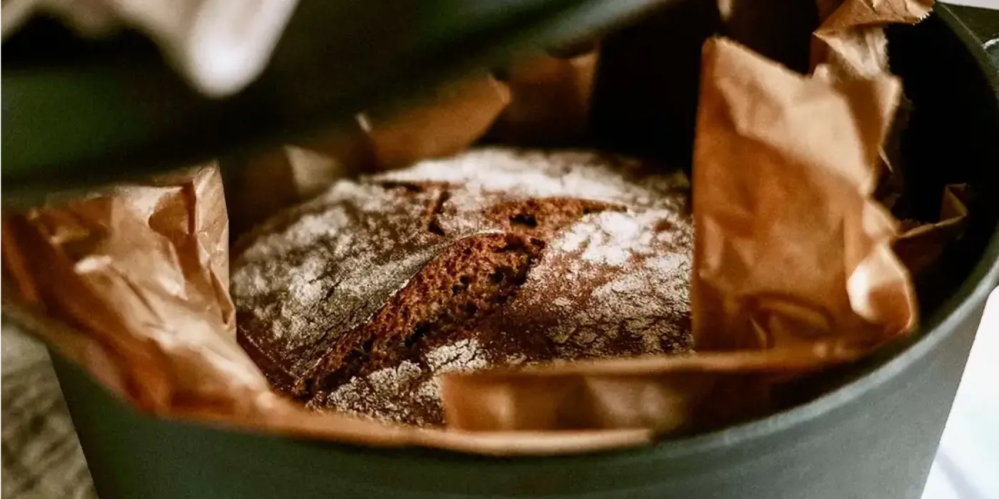 Frisch gebackenes Brot in einem gusseisernen Topf mit Backpapier