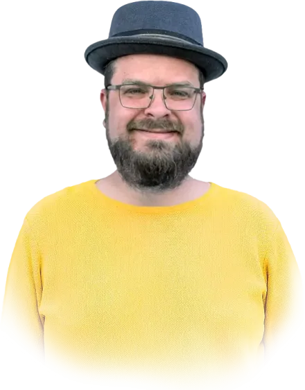 Lächelnder Mann mit Hut, Brille und gelbem Pullover vor transparentem Hintergrund