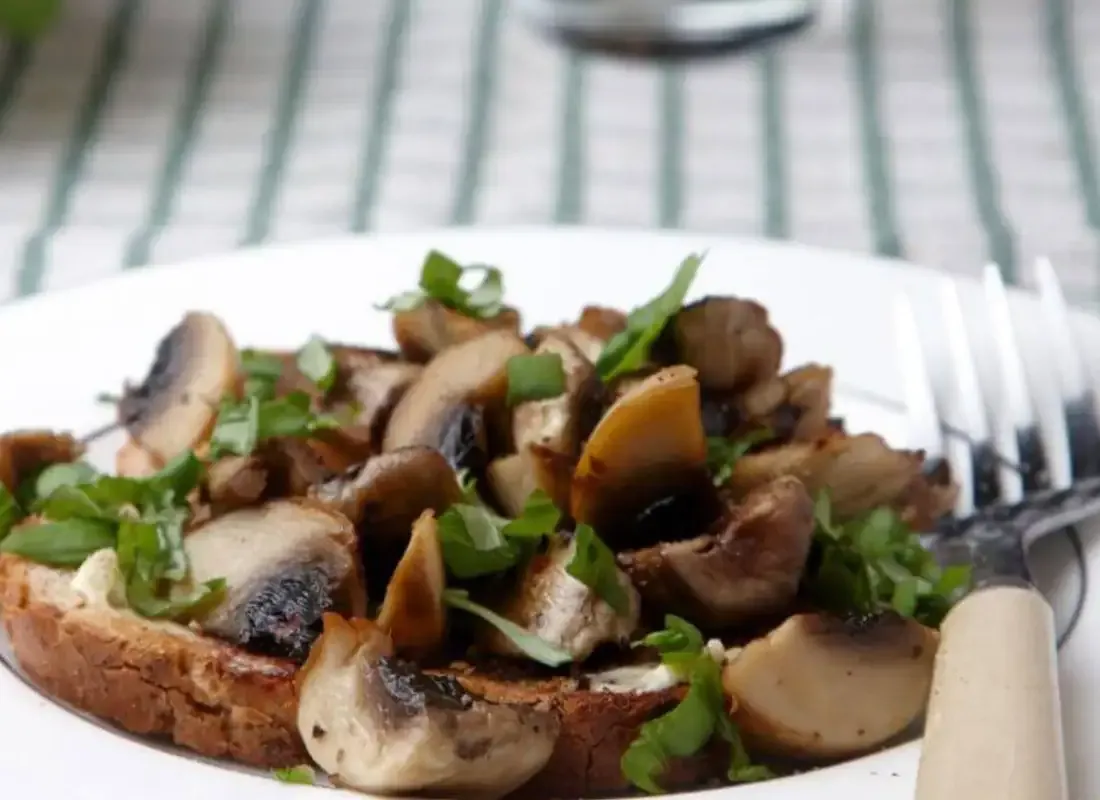Geröstetes Brot mit gebratenen Champignons und frischen Kräutern